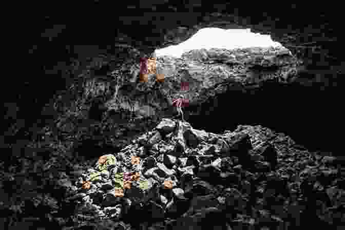 A Hiker Explores A Narrow Lava Tube Within Craters Of The Moon National Monument, Surrounded By Volcanic Rock Formations Craters Of The Moon: Craters Of The Moon National Monument